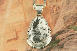 White Buffalo Turquoise set in Sterling Silver Pendant. This Beautiful Stone is formed from the minerals Calcite and Iron. It is mined near Tonopah Nevada. Free 18" Sterling Silver Chain with Purchase of Pendant. Created by Navajo Artist Arkie Nelson. Signed by the artist.